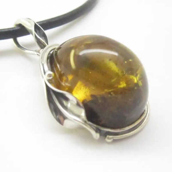 Szczątki roślinne w przezroczystym bursztynie i srebro oksydowane - zawieszka z rzemieniem