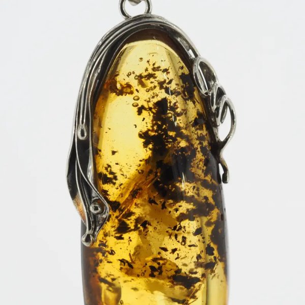 Przezroczysty bursztyn z szczątkami organicznymi, pęcherzykami powietrza  i srebro oksydowane - zawieszka