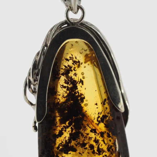 Przezroczysty bursztyn z szczątkami organicznymi, pęcherzykami powietrza  i srebro oksydowane - zawieszka
