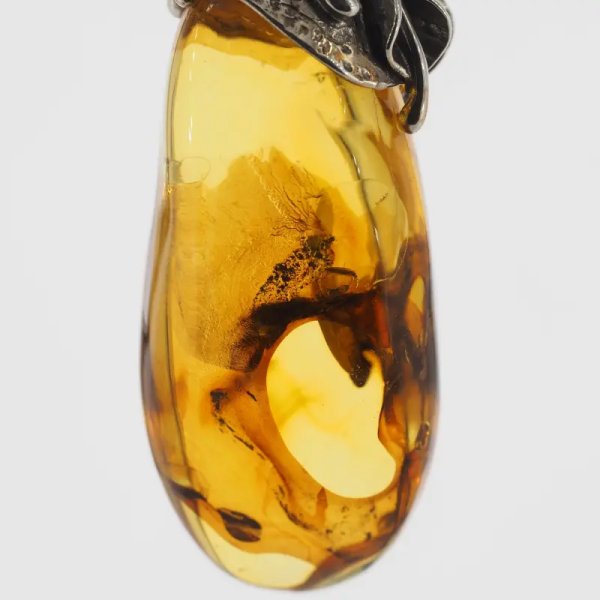 Przezroczysty bursztyn z szczątkami roślinnymi  i srebro oksydowane - zawieszka