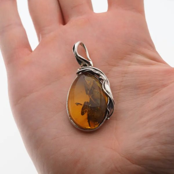 Przezroczysty bursztyn z szczątkami liści  i srebro oksydowane - wisiorek