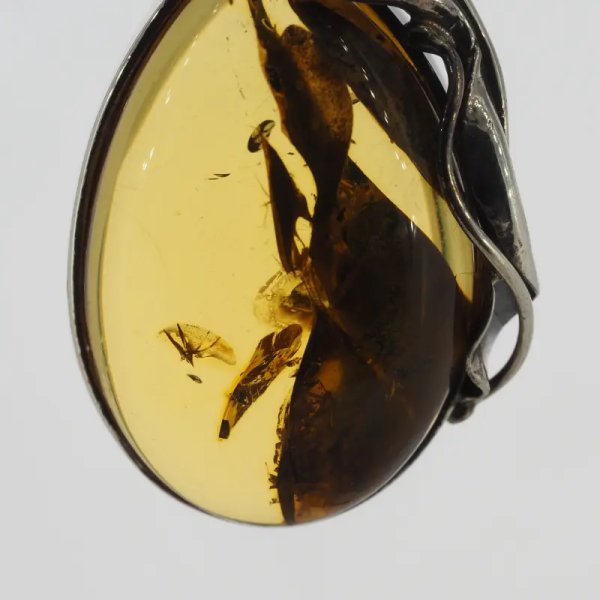 Przezroczysty bursztyn z szczątkami liści  i srebro oksydowane - wisiorek