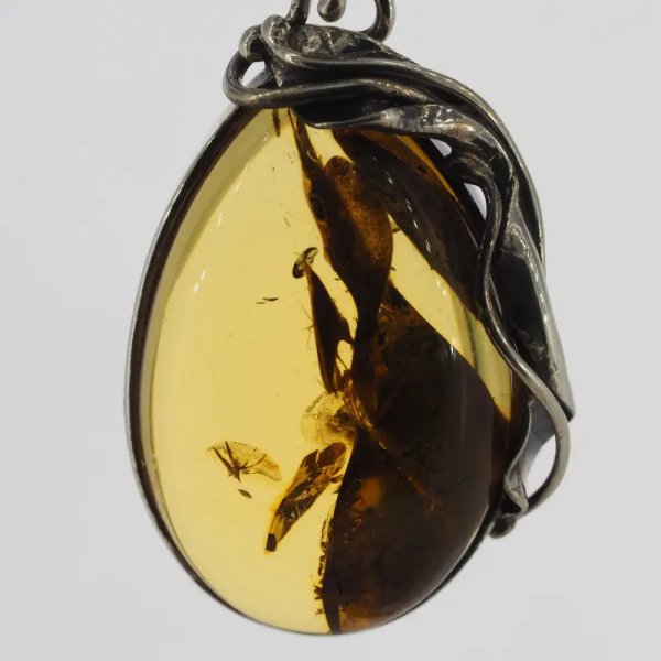 Przezroczysty bursztyn z szczątkami liści  i srebro oksydowane - wisiorek