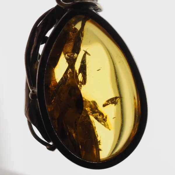 Przezroczysty bursztyn z szczątkami liści  i srebro oksydowane - wisiorek
