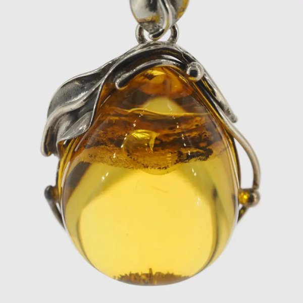 Przezroczysty bursztyn z szczątkami roślinnymi  i srebro oksydowane - wisiorek
