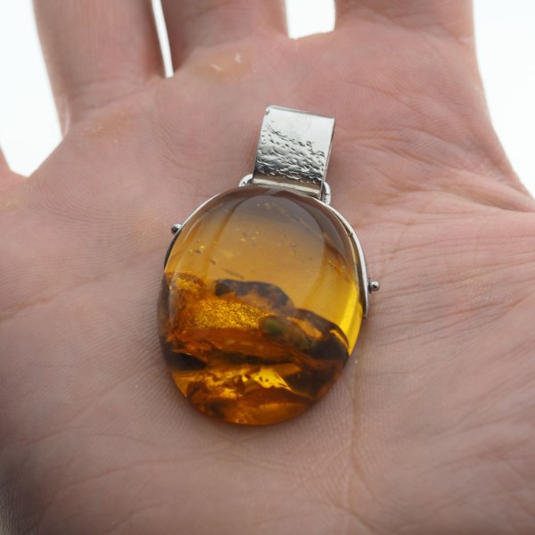 Bursztyn z inkluzją i młotkowane srebro oksydowane - zawieszka z rzemieniem