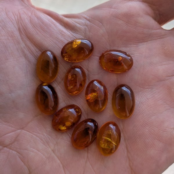 Bursztyn koniakowy z wewnętrznymi łuskami kaboszony owalne 15x10 mm – pakiet 10 szt.