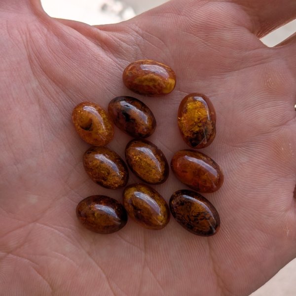 Bursztyn koniakowy z wewnętrznymi łuskami kaboszony owalne 15x10 mm – pakiet 10 szt.